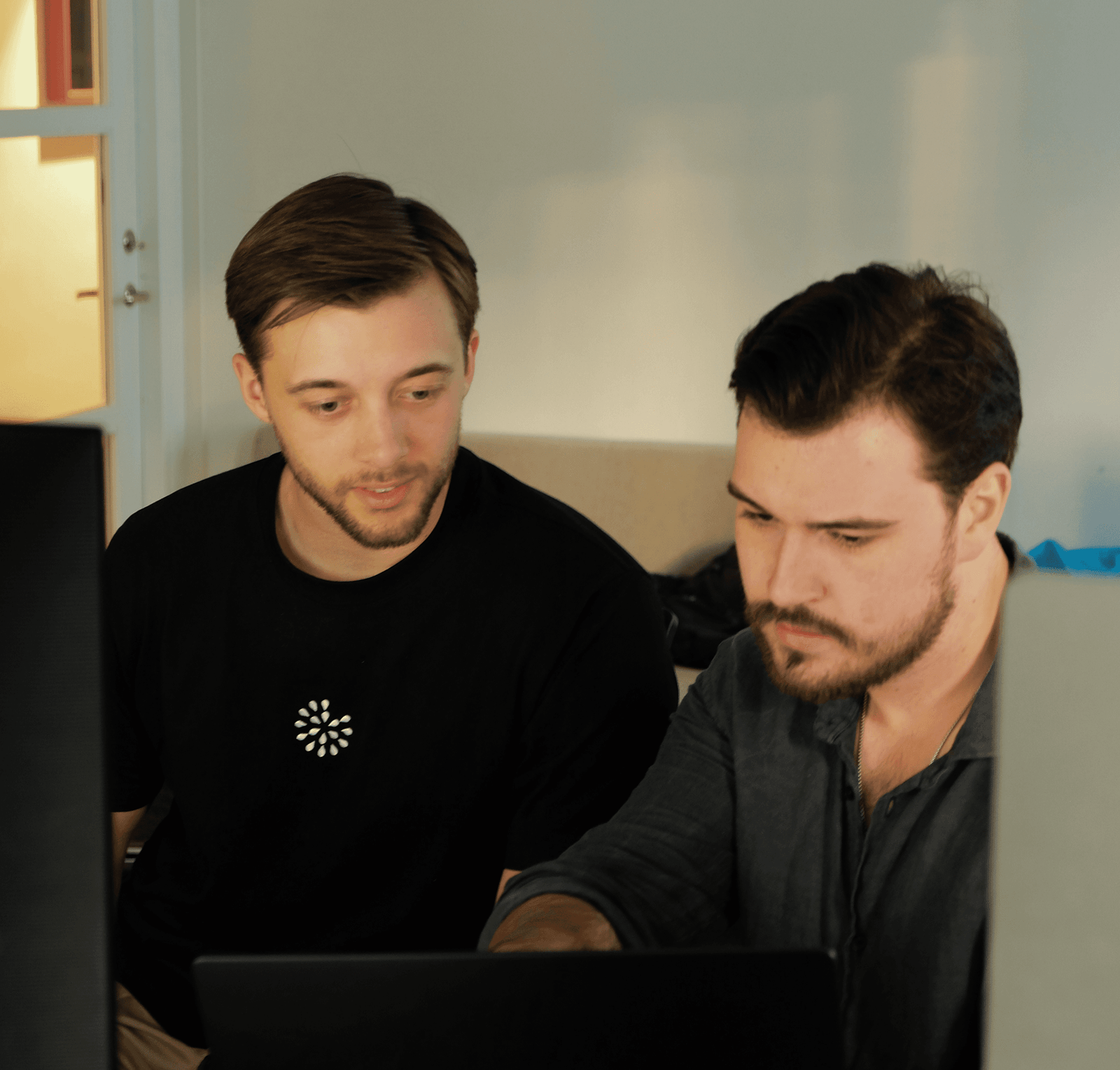 Two Scape teammates working together at a laptop.